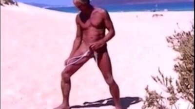 Tanned guy on beach in tiny string thong (temporarily!) on vidfreenow.com