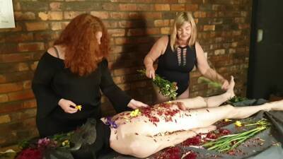 Gorgeous Femdom Duo Flogs Cheating Slave With Flowers on vidfreenow.com