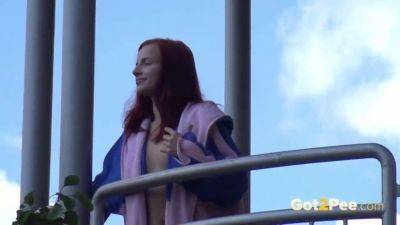 Watch this kinky redhead get a public surprise while peeing in the city on vidfreenow.com