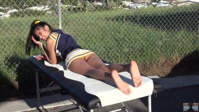 Cheerleader without panties sunbathing on the massage table on vidfreenow.com