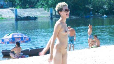 Nude beach girl chats with her friends lays naked and enjoys the sun on vidfreenow.com